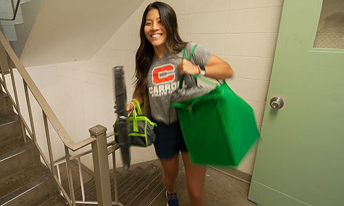 a Carroll University student carrying bags.