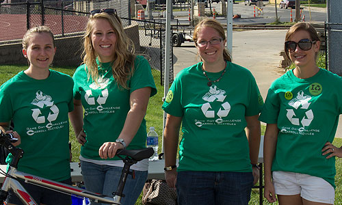 four women standing next to each other wearing recyling shirts.