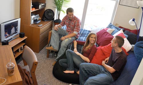 Photo of three students watching TV in dorm